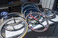 Multiple bicycle wheels and rims arranged on table