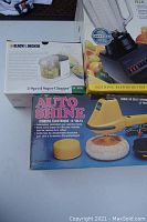 Photo of boxed Black & Decker 2-speed Super Chopper, Oster blender, and boxed Auto Shine 12V electric polisher.