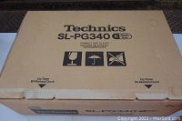 Closed original box showing Technics branding and model SL-PG340 K, fragile and handling icons printed on the cardboard.
