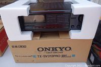 Front view of Onkyo TX-SV313PRO installed in foam packaging on original box