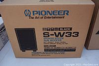 Cardboard box labeled Pioneer S-W33 speaker system subwoofer, black, with product details and weight.