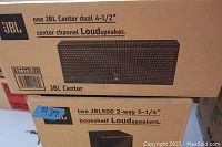 Boxes showing JBL Center dual 4-1/2 inch center channel loudspeaker and two JBL500 2-way 5-1/4 inch bookshelf loudspeakers, unopened and stored new.