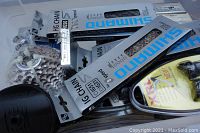 Clear top-view of bin showing multiple Shimano HG50 chain packages and a yellow XRL packet