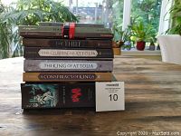 Stack of young adult fiction books by Megan Whalen Turner and a black and white graphic novel 'Bone' along with a black and white Art Spiegelman collection book at bottom.