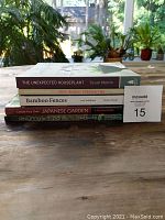 Side view of five gardening books stacked, showing titles and authors.