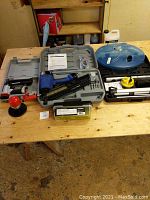 Overview of all included tools on workbench: framing nailer, nails, brad nailer, rotating tool, laser level, Cyclone lid