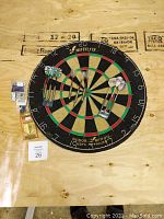 Full view of dartboard and darts arranged on a wooden surface with accessories included.