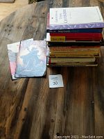 Photo of stacked hobby-related books including titles on lavender, Paris, and music with two comic books nearby.