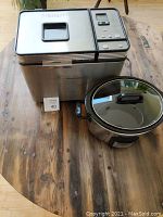 Photo showing the Cuisinart convection bread maker and the Crockpot slow cooker on a wooden table.