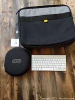 Set overview showing Apple Bluetooth keyboard, Maxell headphone case, and Targus laptop bag on a wooden surface.