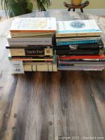 Two stacks of classic fiction and literary books on table showing their spines and covers for identification.