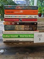 Stacked view of 9 hardcover and trade fiction books showing titles and condition
