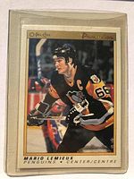 Front view of Mario Lemieux hockey card showing him in Pittsburgh Penguins uniform skating in game action.