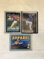 Front side of three Roy Halladay baseball cards showing pitching images and an embedded blue fabric patch.