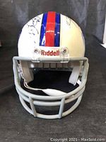 Front view of miniature Buffalo Bills helmet with red and blue stripe and visible signatures.