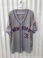 Front view of gray New York Mets baseball jersey with New York text, number 31, and World Series patch on sleeve.