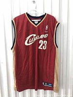 Front view of red Cleveland Cavaliers basketball jersey, number 23, with Reebok logo and NBA patch.
