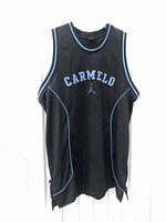 Front view of black sleeveless basketball jersey with light blue piping and 'CARMELO' printed on chest with Jordan Jumpman logo below.