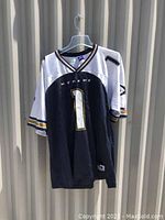 Full front view of the black, white, gold, and navy XFL football jersey with number 1 and "XTREME" text.