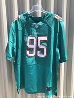 Front view of green Miami Dolphins jersey with number 95 and player name Dion Jordan.
