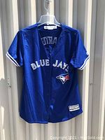 Front view of the blue Toronto Blue Jays baseball jersey with 'BLUE JAYS' text and team logo.