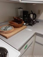 Kitchen counter display showing Betty Crocker coffee maker, Sunbeam electric kettle, vintage Waring blender with wood bowls and cutting board beside them.