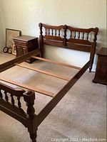 Photo of the solid wood bed frame showing headboard, footboard, side rails and slats, revealing condition and style.