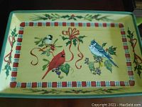 Top view of a large rectangular plate with Lenox Winter Greetings design showing cardinal, blue jay, and chickadee with ribbons and holly borders.