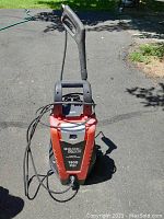 Front view of the Black & Decker electric pressure washer showing brand, model and PSI rating with attached power cord.
