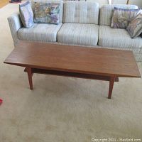 Front perspective view of coffee table on carpet in front of sofa