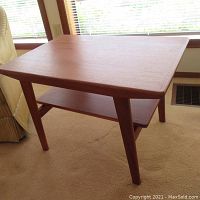 Full front and side view of the teak end table on carpet