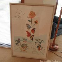 Overview of entire framed print leaning against window blinds