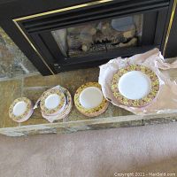 Wide shot showing multiple stacks of plates arranged with largest on the right to smallest on the left. Each plate has a colorful decorative rim.
