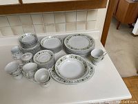 Full set of Townhouse Greendale China including plates, bowls, cups, saucers, creamer, and sugar bowl arranged on countertop.