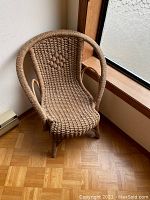 Front and angled views of the vintage wicker children's chair showing detailed weaving, rounded back, and armrests.