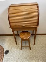 Desk closed with tambour roll-top door and matching stool positioned in front
