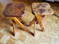 Pair of handmade burlwood plant stands on parquet flooring showing octagonal tops with burl pattern and three angled legs