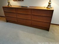 Front view of nine-drawer teak dresser