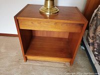 Front view of teak veneer end table showing top, drawer, and lower shelf