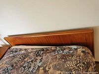 Full view of teak-veneer headboard installed behind mattress