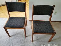 Pair of teak mid-century modern style chairs with black upholstery viewed from front and top.
