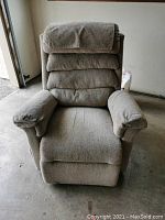 Front angle view of the beige upholstered electric lift chair showing armrests, cushioned seat and backrest.