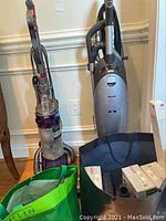 Both vacuums side by side with bags and accessories displayed