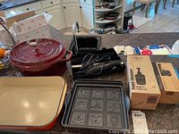 Overview of lot on kitchen counter: Dutch oven, baking dish, mold, chopper box, cutter parts