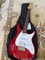 Overall front view of red Peavey Raptor EXP electric guitar inside gig bag