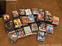 Full view of multiple stacks of DVDs and Blu-rays on floor, assorted titles and genres visible