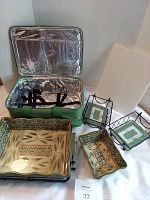 Set displayed including insulated travel case (green, thermal lined), 3.5 quart ceramic casserole with plastic lid, 1 quart ceramic casserole, two wire racks each with glass trivet holders featuring decorative patterns.