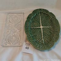 Photo showing both items together: green cabbage leaf ceramic platter and clear lead crystal rectangular pastry tray