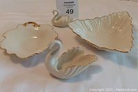 Full view of three Lenox china items: triangular leaf dish, large swan dish, small swan holder, all with gold trim
