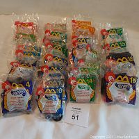 29 McDonald's Hot Wheels Happy Meal toys from 2000, all individually sealed in original plastic bags with Ronald McDonald artwork and Hot Wheels branding. Toys numbered mostly between 1 and 16.